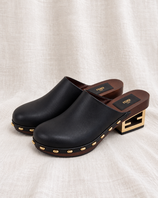 FENDI, Leather Clogs with Gold Logo Heel, 39 — left-facing pair on ivory linen