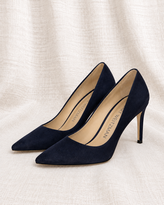 STUART WEITZMAN, Navy Suede Pumps, 8 — left-facing pair on ivory linen
