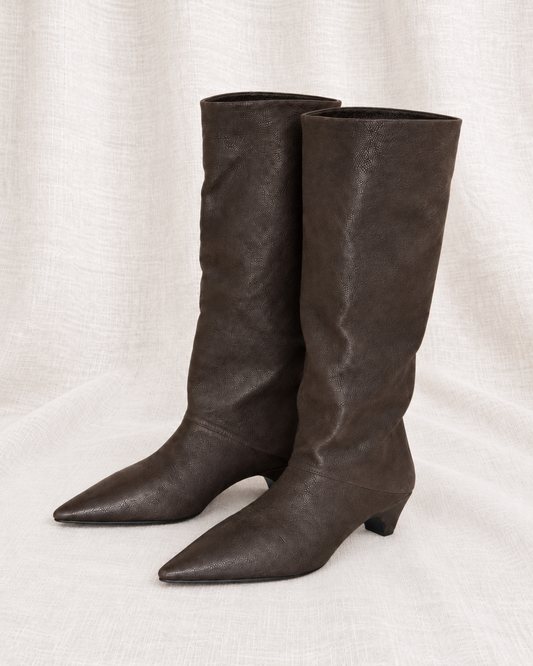 PRADA, Tall Slouchy Leather Boots, 37 — left-facing pair on ivory linen