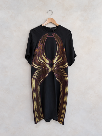 Garment on a wooden hanger against a pale textured wall