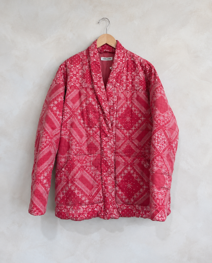 Garment on wooden hanger against pale textured wall