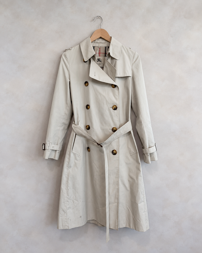 Burberry garment on wooden hanger against pale textured wall
