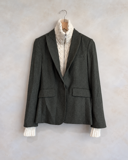 Veronica Beard garment on wooden hanger against pale textured wall