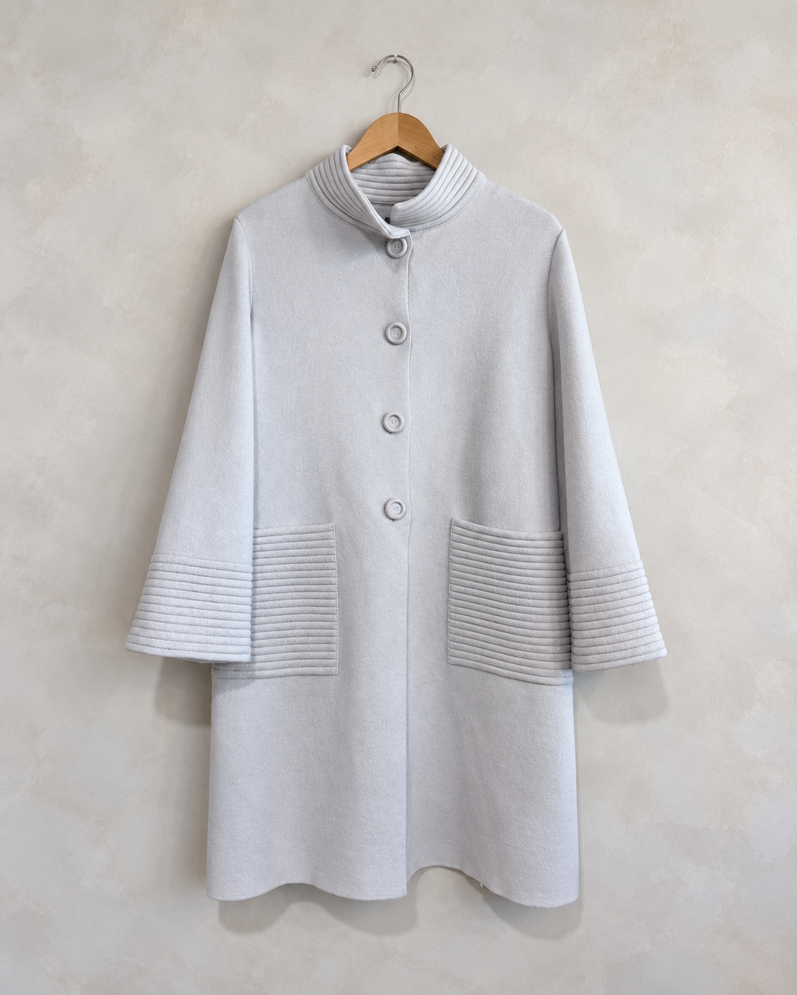 D. EXTERIOR, Wool Coat W Ribbed Collar/Pockets, S on a wooden hanger against a softly mottled pale wall