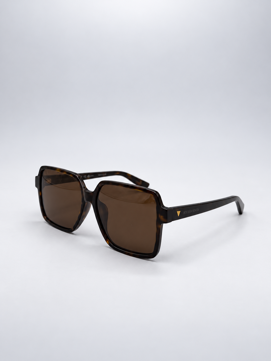 Sunglasses photographed against a soft light gray studio background
