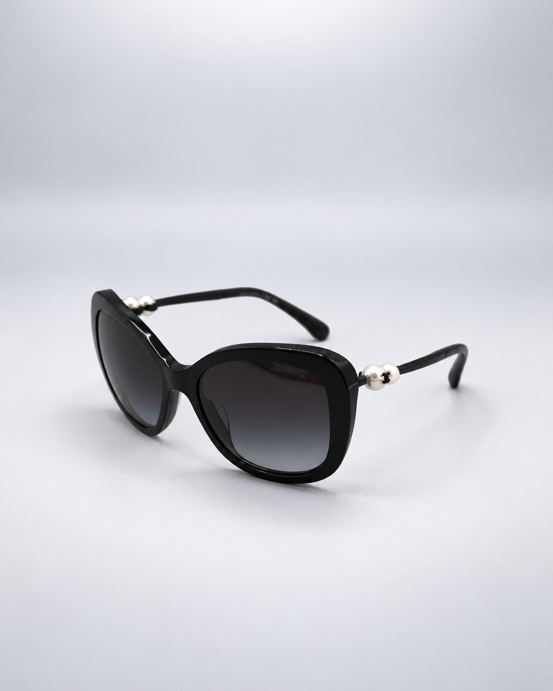 Sunglasses photographed against a soft light gray studio background